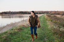 young woman walking outdoors in coat and boots
