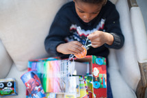 a boy child opening a Christmas gift 
