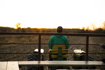 Man sitting on tractor at sunrise