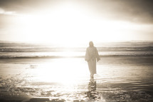Jesus standing on a beach at sunrise 