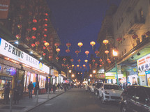 lanterns hanging over a street at night 