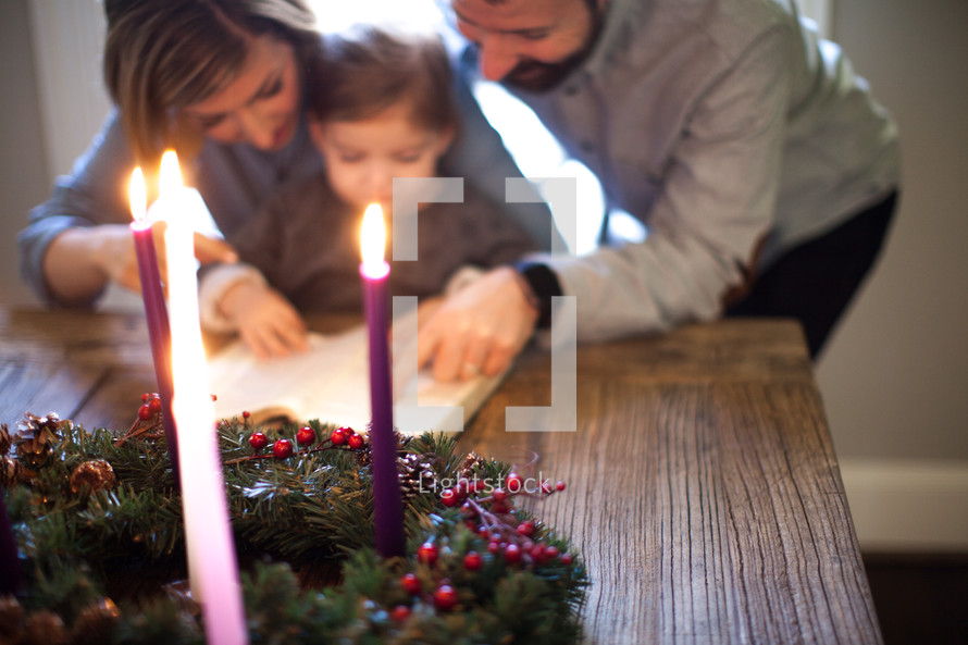 family reading a Bible in front of an Advent wreath 