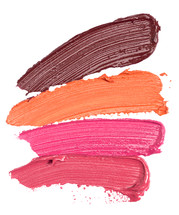 Four Shades of Lipstick and Lip Gloss Swatches Isolated on a White Background