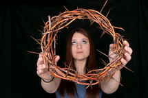 girl holding a crown of thorns 