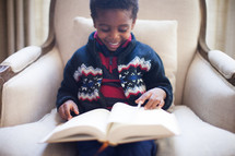 boy child sitting and reading a Bible 