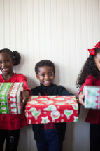 children holding wrapped gifts Christmas 