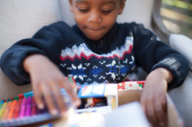 a boy child opening a Christmas gift 