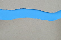 blue under gray torn paper - ripped paper revealing blue blank space for words