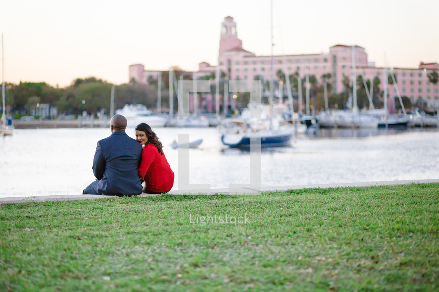 couple sitting together watching boats on the water 