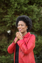 AN African American woman with praying hands 