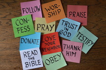 words about christian life behavior on notepads in a pile on a wooden table