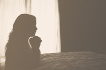 silhouette of a woman in prayer