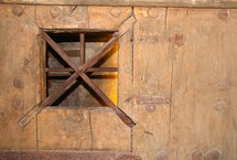 barred window on a wood door 