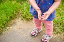 a little girl holding an earthworm 