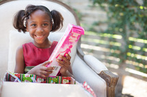 a girl child opening a Christmas gift 