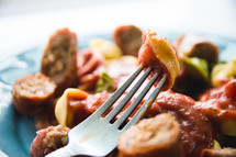 fork in a bowl of sausage and peppers 