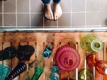 bare feet and colored glass vases 