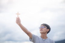 a young man holding up a cross
