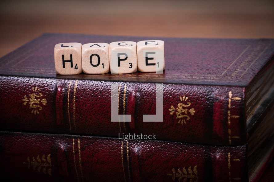 Dice spelling out "hope," on a leather Bible.