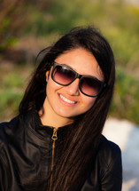 Portrait of a brown-haired teenager with sunglasses.