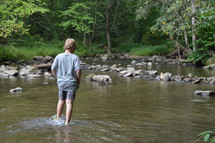 boy standing in shallow water
