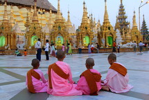 Novice monks sitting in from of Shwedagon, a Buddhist pagoda
