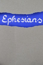 Ephesians - torn open kraft paper over intense blue paper with the name of the letter from Paul to the  Ephesians