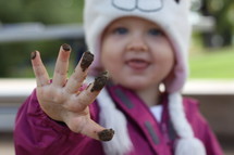 toddler girl playing in mud 
