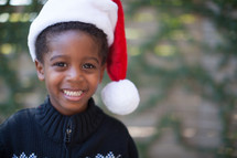 an African American boy child in a Santa hat 
