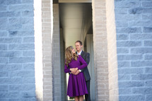 A couple stand together in a doorway.