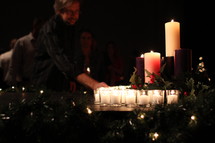A man lighting Christmas candles. 