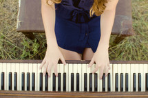 woman playing the piano outdoors