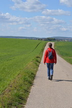 a woman walking down a country road 