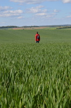 person standing in a green field 