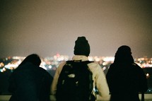people looking out a city lights at night 