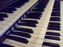 organ keys keyboard on an old pipe organ in a traditional worship service.
