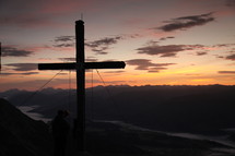 cross at sunset on a mountainside 