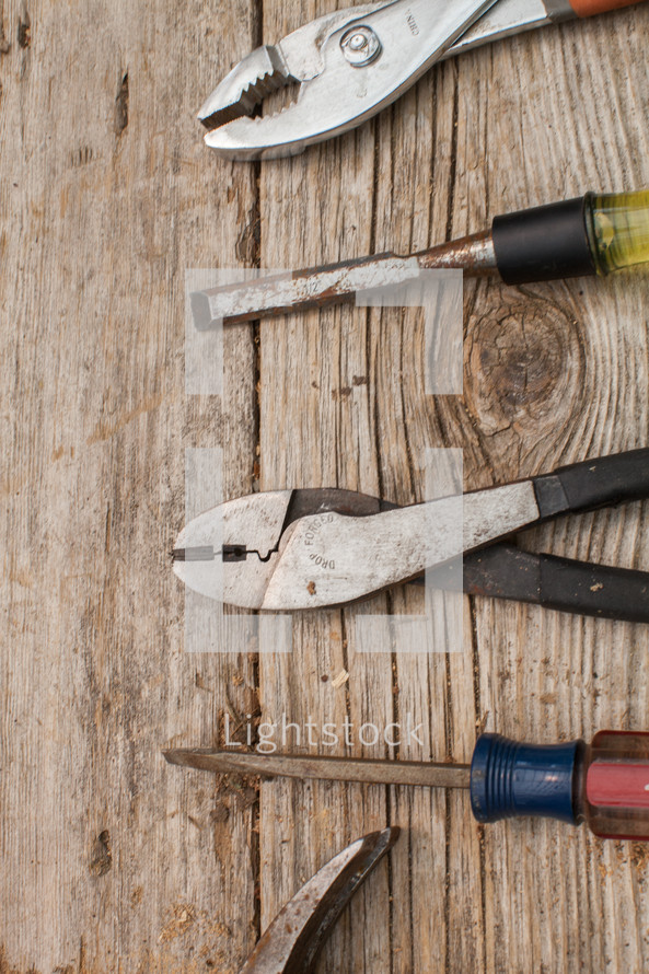 Tools lined up on a rustic wooden table.