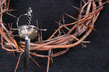 sword and crown of thorns on a black background 