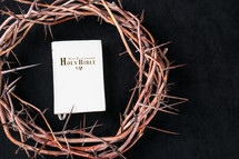 Bible and crown of thorns on a black background 