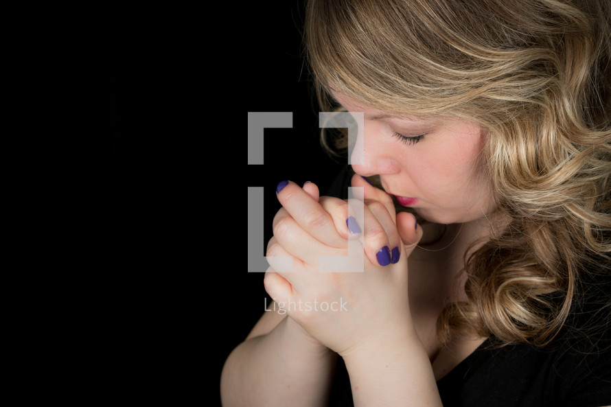 woman with praying hands and painted nails 