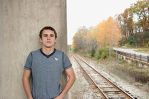man standing near railroad tracks