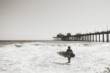 a surfer near a pier 