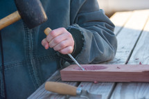 a boy chiseling wood 