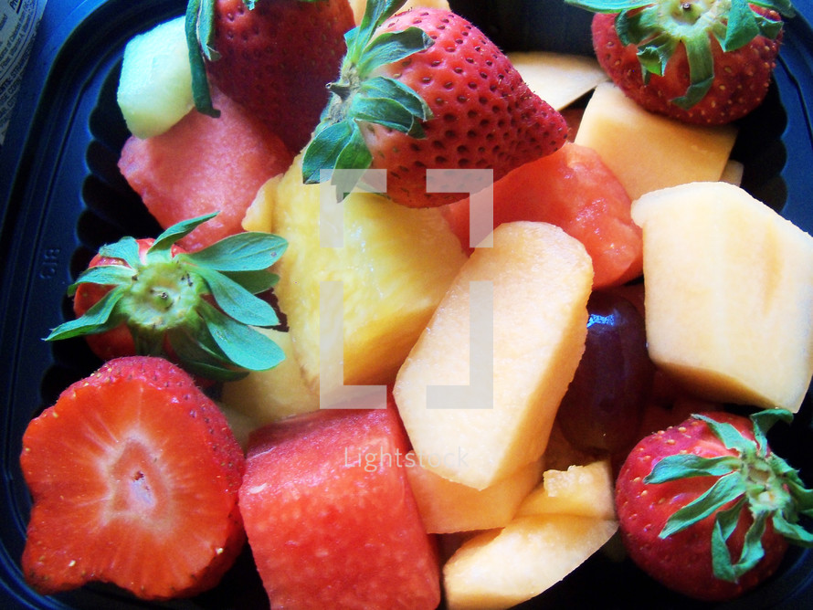 A healthy fruit salad filled with strawberries, melons, pineapple, cantaloupe and other fresh fruit for a healthy meal pleasing to the eye and stomach. 