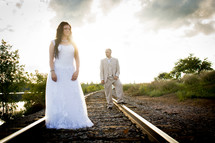 bride and groom on railroad tracks 