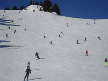 a lot of skiing and boarding people at a ski slope. 
