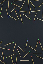scattered matches on a black background