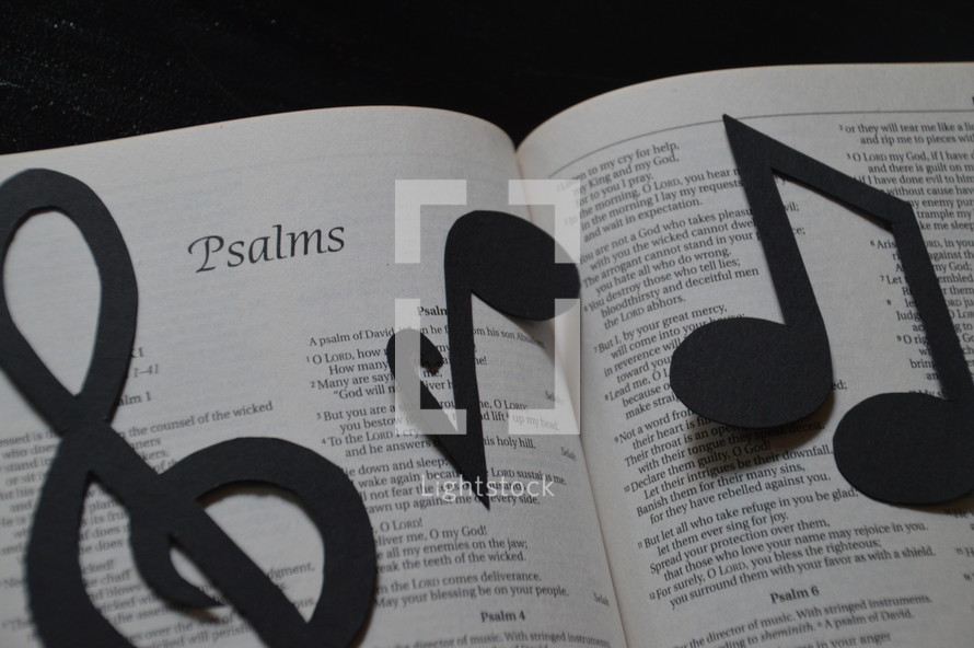 The Bible open to Psalms with musical notes covering it.