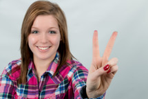 young woman showing a peace sign 